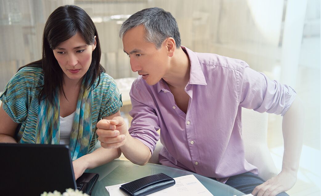 Couple looking at a laptop and having a discussion