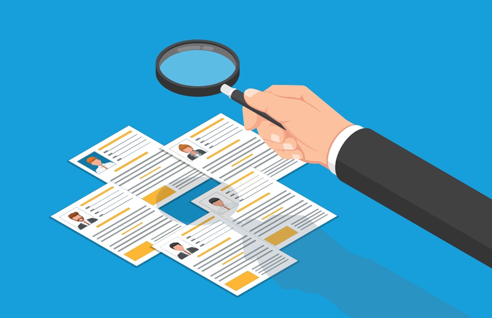 Graphic of a magnifying glass looking at employee profiles.