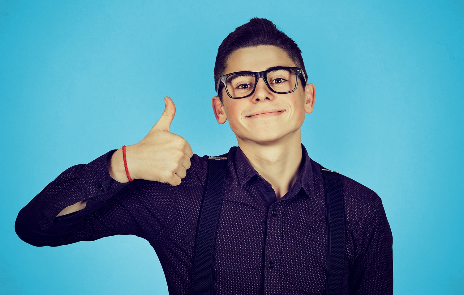 Teen boy with glasses giving thumbs up