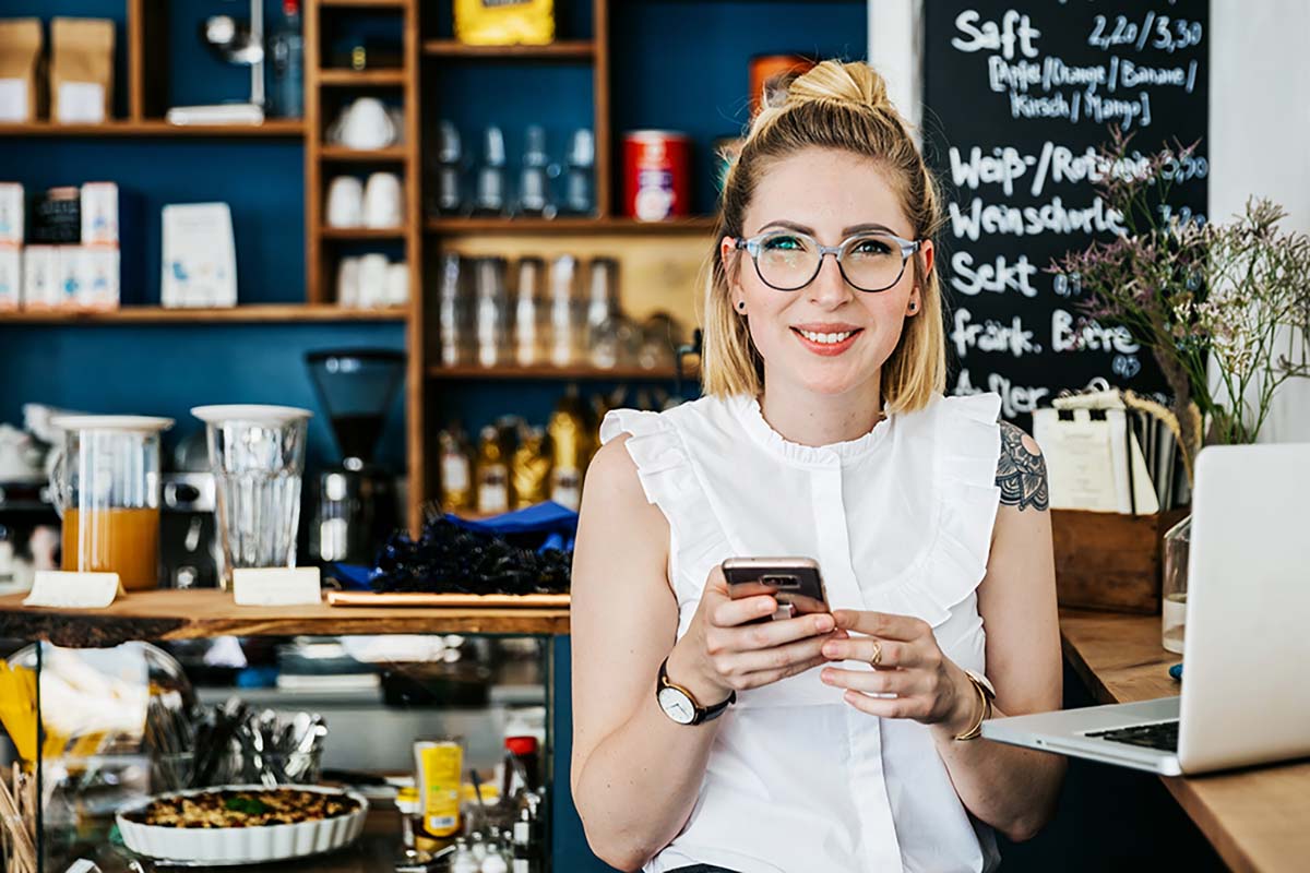 women holding phone at coffee shop