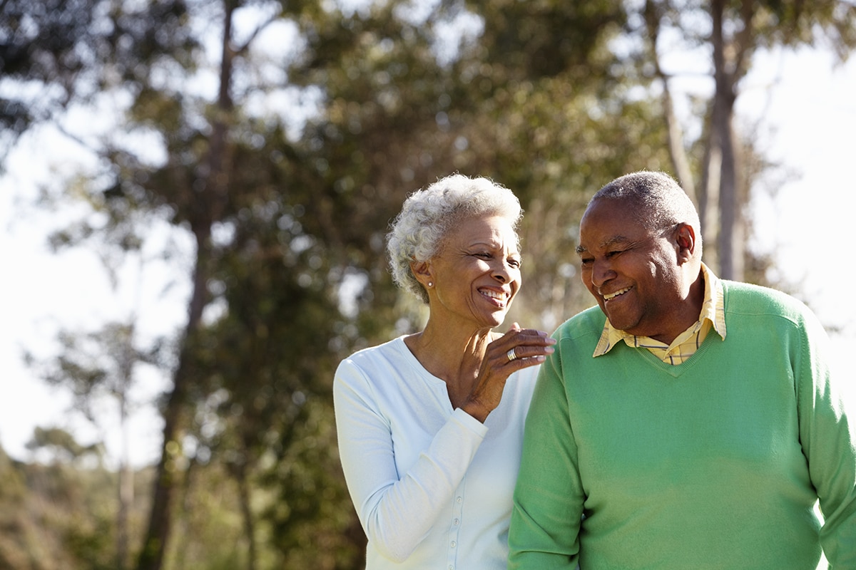 An older black couple walking and smiling