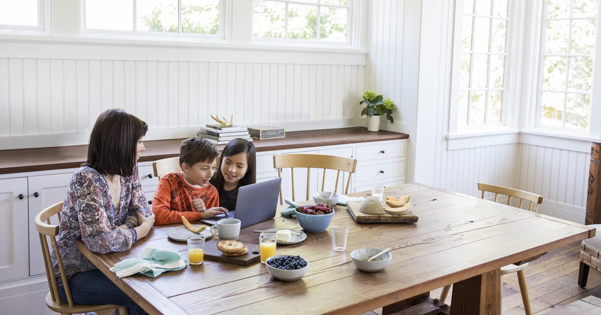 A mother with her children sitting at the table.