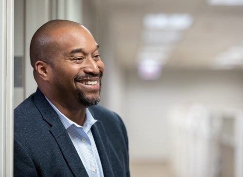 Smiling man standing outside an office