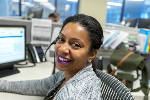 Smiling woman with headset at her desk