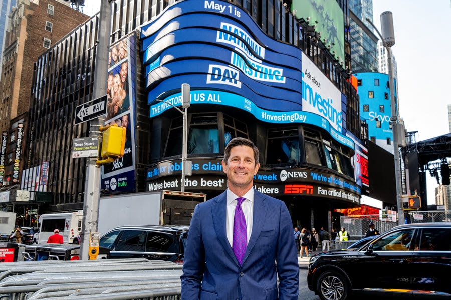 Schwab CEO in Times Square under the National Investing Day digital sign