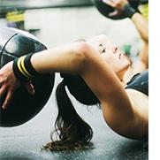 Woman lifting a weighted ball.