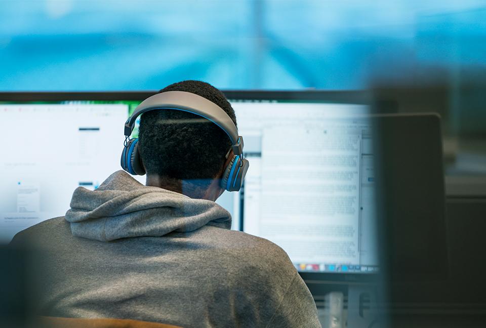 Man staring at computer screens.