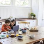 A mother with her children sitting at the table.
