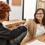 Two women shaking hands.