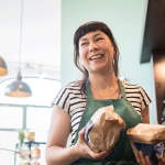 Smiling shopowner holding bags of food