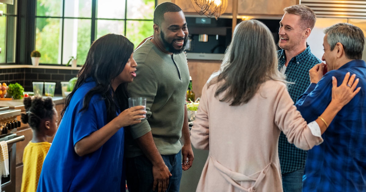 Group of adult friends socializing in a kitchen