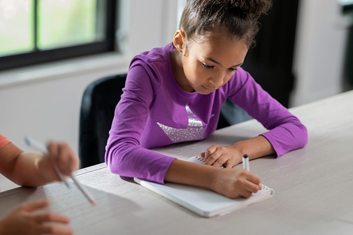 Little girl writing in a notebook